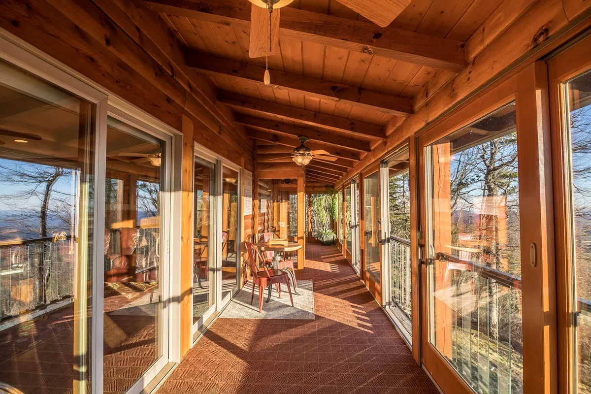 A bright dining nook with a wooden ceiling, large glass doors, and windows that open to scenic outdoor views. The inviting space is perfect for casual meals, morning coffee, or reading breaks while staying visually immersed in the mountain landscape.