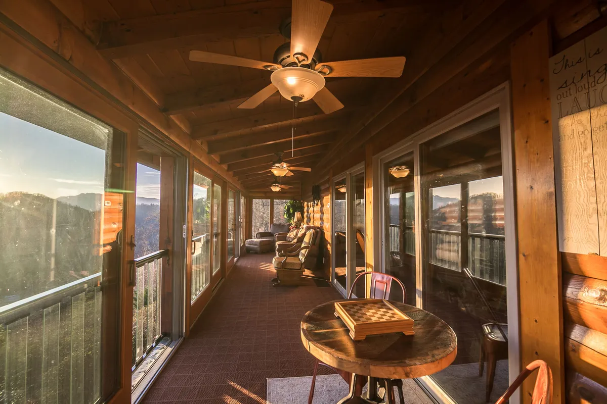 A bright interior room featuring large windows with scenic views, comfortable seating, and a wooden table set up for board games. The space is filled with natural light, inviting families to bond over games or simply enjoy the beautiful surroundings from inside.