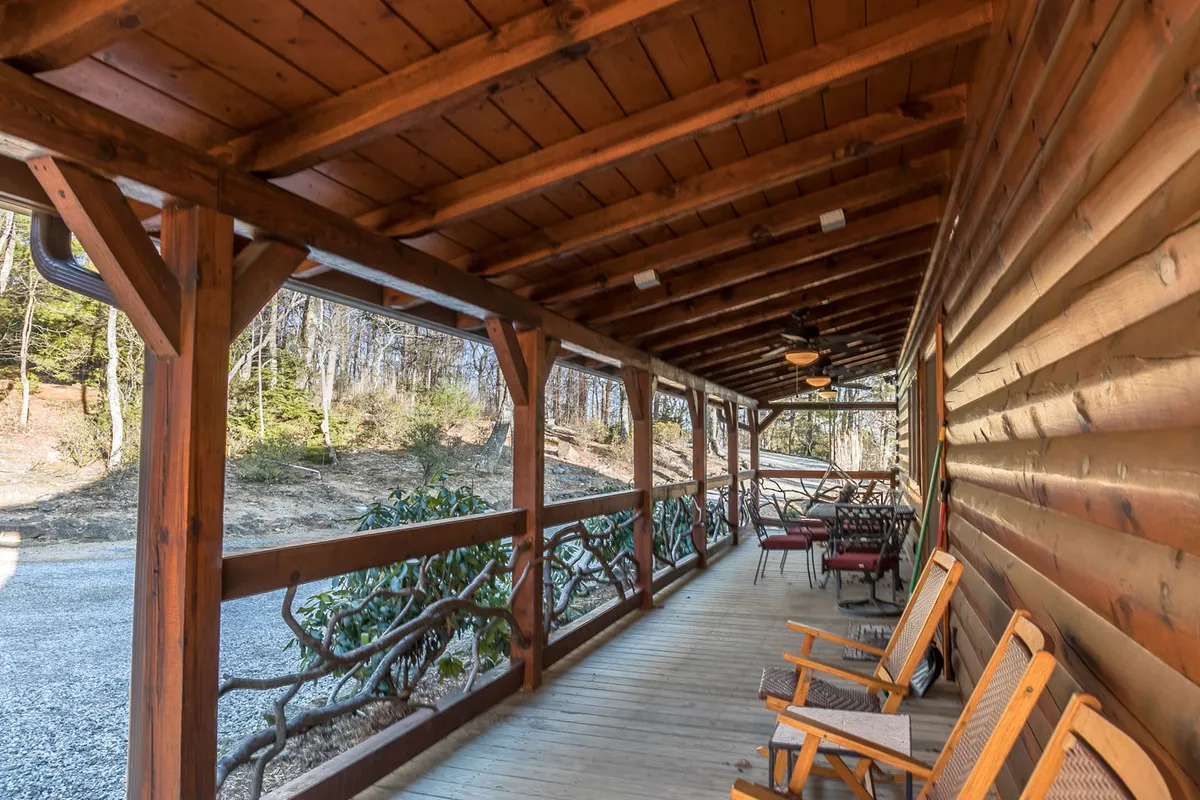 A cozy porch scene with wooden rocking chairs and a rustic railing, surrounded by natural beauty. The tranquil outdoor space is ideal for relaxing conversations, watching sunsets, or family moments after a day of adventure.